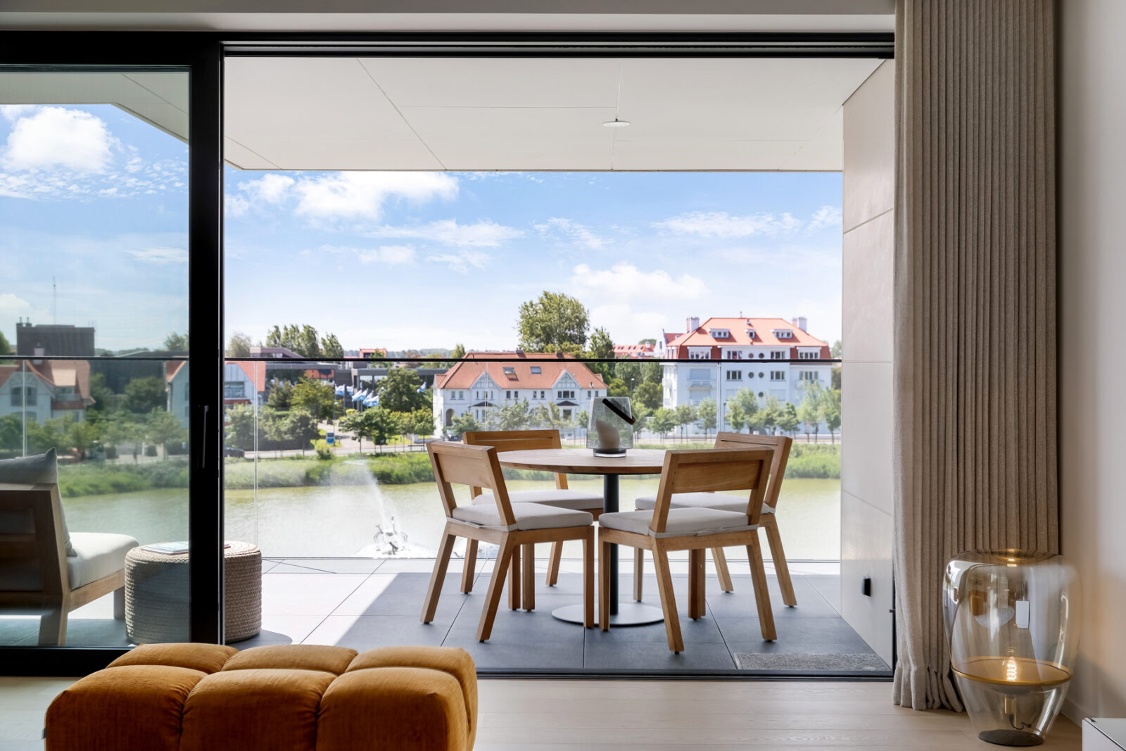 Interieurfotografie van moderne eetruimte met uitzicht op het Zegemeer en de Waving Crabs fontein in Knokke, gefotografeerd vanaf een ruim balkon.