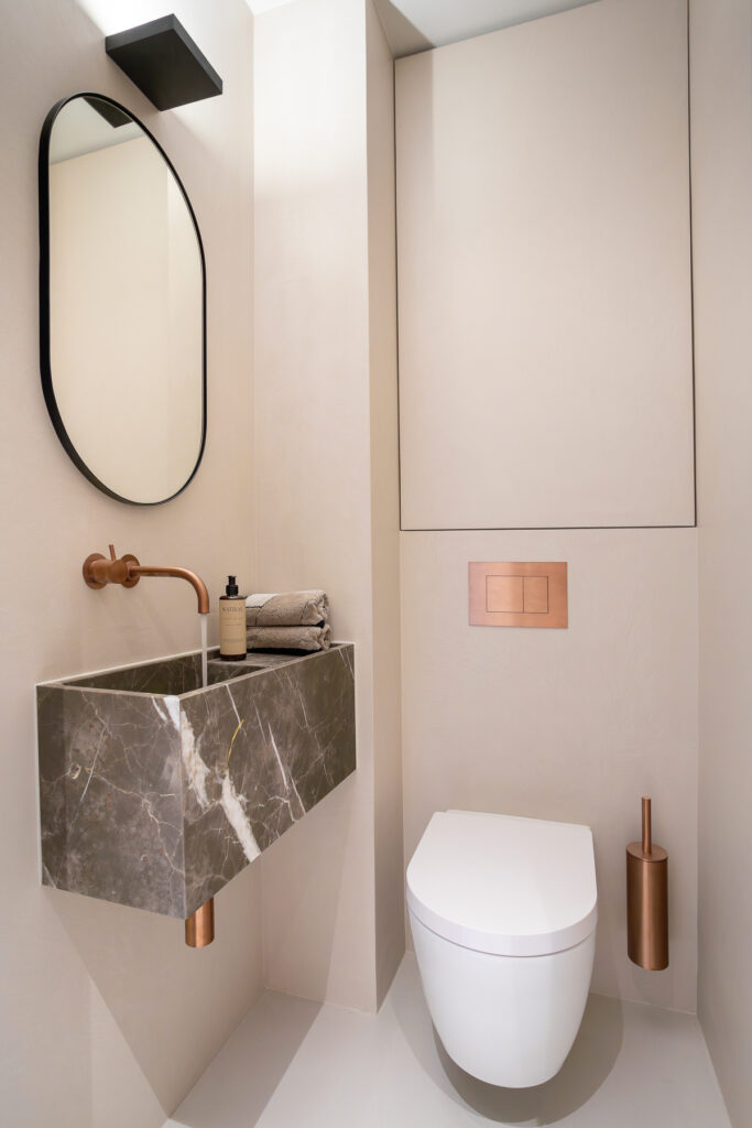 Detail interieurfoto van een maatwerk high-end toilet uitgevoerd in mortex en met marmeren meubel