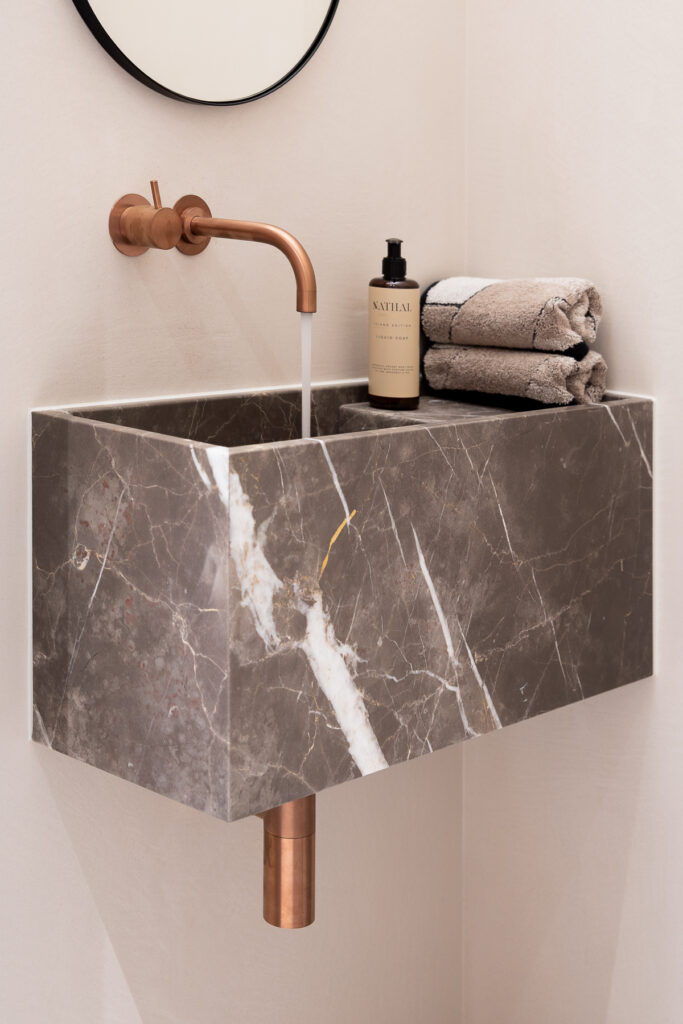 Detail interieurfoto van een maatwerk high-end toilet uitgevoerd in mortex en met marmeren meubel