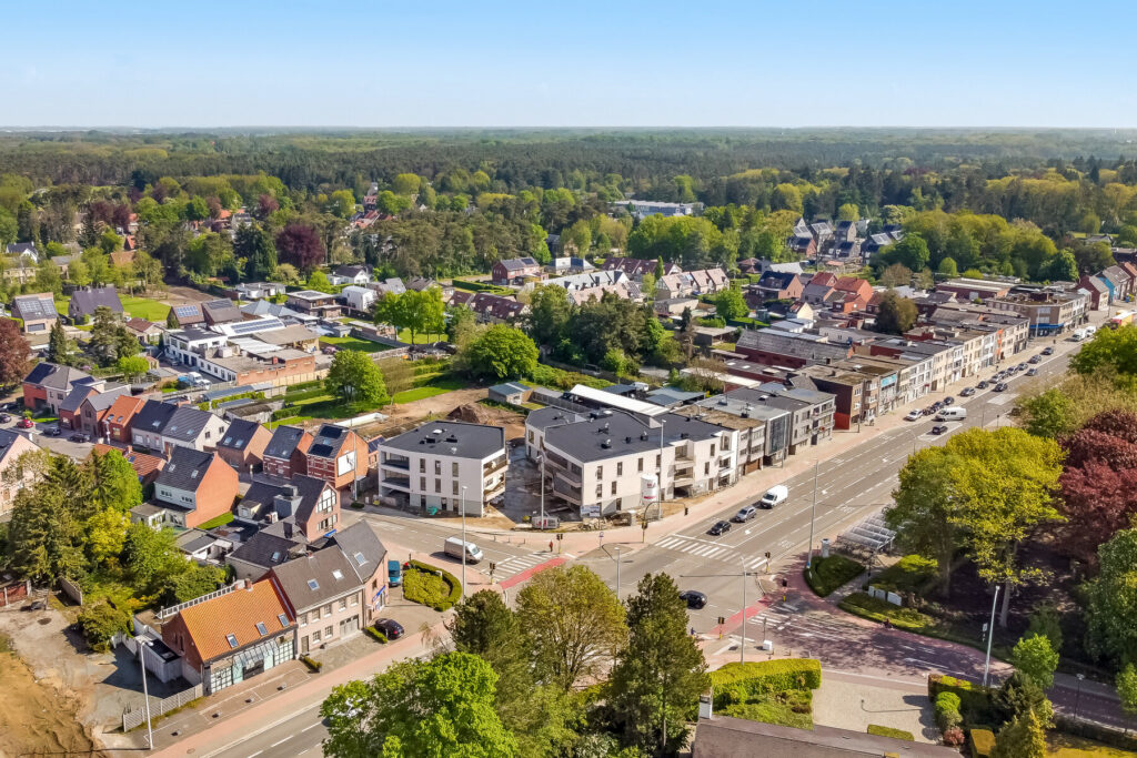 Dronefotografie van een nieuwbouw projectwikkeling van een kleinschalig appartementencomplex. Door de hoogte wordt de ligging in het dorp goed zichtbaar. 