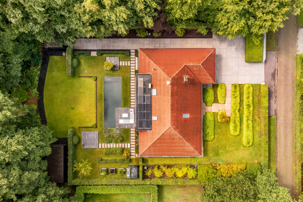 dronefotografie - bovenaanzicht van villa met natuurlijke zwemvijver. Omringd door bossen.